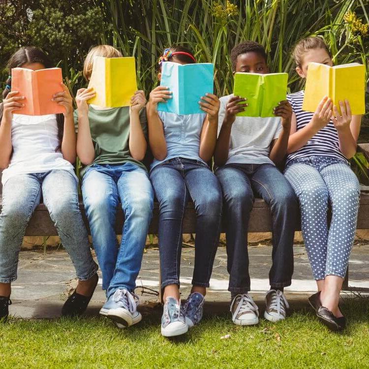 kids reading books on bench